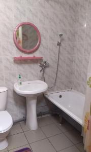 a bathroom with a sink and a toilet and a mirror at Hotel Kuibyshevskaya in Novokuznetsk