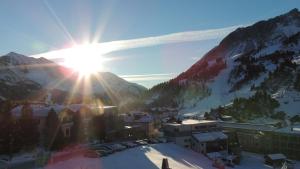 a view of a town in the mountains with the sun at Haus Helga Obertauern in Obertauern