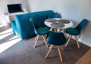 einen Tisch und 4 Stühle in einem Zimmer mit einem Sofa in der Unterkunft Twoje Rydzewo in Rydzewo