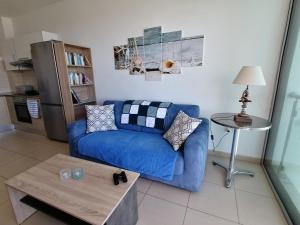 a living room with a blue couch and a table at Coralli Superior Seaview in Protaras