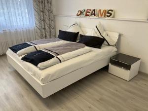 1 dormitorio con 1 cama blanca grande con almohadas negras en Ferienwohnung Breisgau, en Bad Krozingen