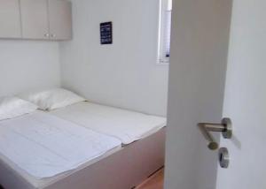ein weißes Bett in einem Zimmer mit offener Tür in der Unterkunft Beach Chalet SunHus - modernes Chalet in Ostseenähe in Scharbeutz