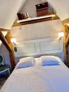 a white bed with two pillows in a room at La Ferme de Marie in Rangen