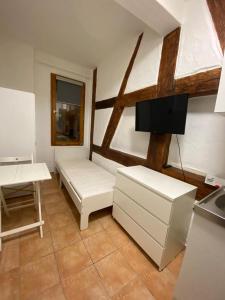 ein Wohnzimmer mit weißen Möbeln und einem TV in der Unterkunft Apartment nahe Unikliniken in Erlangen