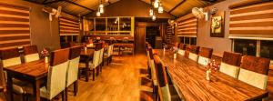a restaurant with a long wooden table and chairs at BANALARI PINE INN in Shillong
