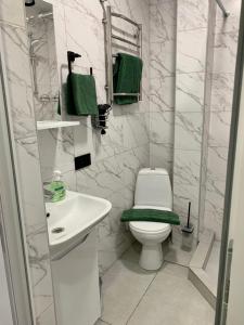Łazienka z białą toaletą i umywalką w obiekcie Green room в ЖК Рич Таун Ирпень w mieście Irpień