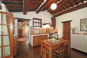 a kitchen with a wooden table and a kitchen with a counter at Agriturismo Sommavilla in Cortona