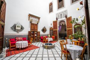 a living room with red chairs and a table at Riad Arabella Fès in Fez