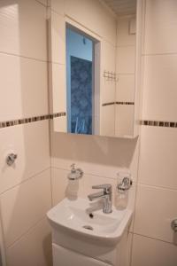 a white bathroom with a sink and a mirror at Mia Kiviõli Apartment in Kiviõli