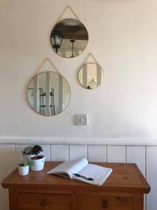 una mesa con dos espejos y un libro en ella en CHAMBRE D'HOTE AU MOULIN DE LONGUEIL en Longueil
