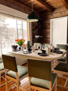une salle à manger avec une grande table et des chaises dans l'établissement Saariselällä, sielukas hirsimökki - Unique cottage, à Saariselka