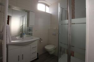 a white bathroom with a sink and a toilet at Relax Hotel-Ludwigshafen in Ludwigshafen am Rhein +95 photos