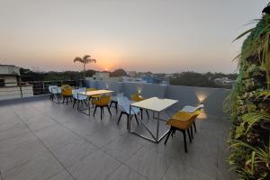 a patio with tables and chairs on a roof at Hotel Blue Bells in Indore