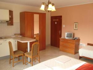 a kitchen with a table and chairs in a room at Studio apartman in Omišalj