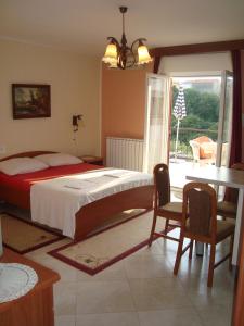 a bedroom with a bed and a table and chairs at Studio apartman in Omišalj