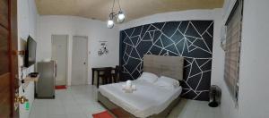 a bedroom with a bed with a blue and white wall at DJCI Apartelle Walk to Robinson & NE Pacific Mall 3 Min to SM Cabanatuan in Cabanatuan