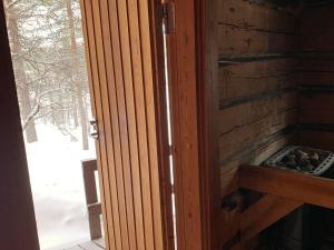 an open door to a fireplace in a log cabin at Saariselällä, sielukas hirsimökki - Unique cottage in Saariselka