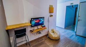 a room with a desk with a television and a chair at Roots Apartment in Zambujeira do Mar