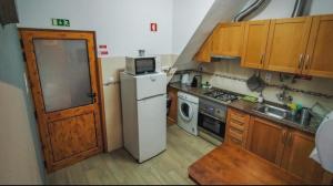 una pequeña cocina con nevera y microondas en Roots Apartment en Zambujeira do Mar