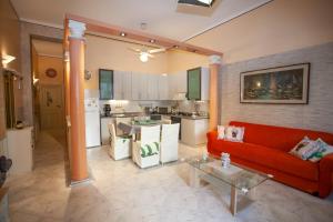salon z czerwoną kanapą i kuchnią w obiekcie Casa RosaMaria w mieście Giardini Naxos +33 zdjęcia