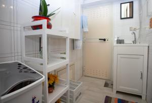 łazienka z białymi półkami i umywalką w obiekcie Casa RosaMaria w mieście Giardini Naxos