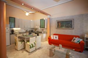 salon z czerwoną kanapą i kuchnią w obiekcie Casa RosaMaria w mieście Giardini Naxos