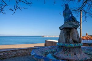 posąg kobiety siedzącej na fontannie w obiekcie Casa RosaMaria w mieście Giardini Naxos