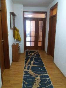 a hallway with a door and a rug on the floor at Vila Ratković in Banja Luka