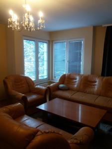 een woonkamer met banken, een tafel en ramen bij Vila Ratković in Banja Luka