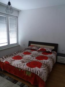 ein Schlafzimmer mit einem Bett mit roten Blumen darauf in der Unterkunft Vila Ratković in Banja Luka