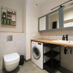 uma casa de banho com uma máquina de lavar roupa e um lavatório em 3 Kolory - pokoje w mieszkaniu współdzielonym em Varsóvia