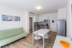 a kitchen and dining room with a table and chairs at MIMOSE Lido Altanea in Caorle