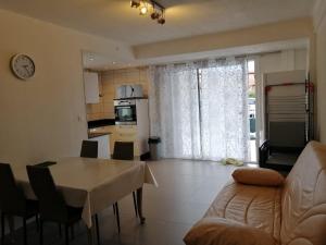 eine Küche und ein Wohnzimmer mit einem Tisch und einem Sofa in der Unterkunft T3 à Saint cyprien plage (400m de la plage) in Saint-Cyprien