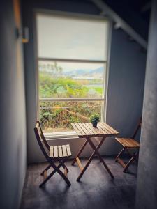 una mesa y dos sillas frente a una ventana en 埔里隱巷人文行旅民宿 en Puli