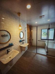 a bathroom with two sinks and a shower and a tub at 埔里隱巷人文行旅民宿 in Puli