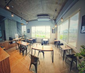 um restaurante com mesas e cadeiras em uma sala em 埔里隱巷人文行旅民宿 em Puli