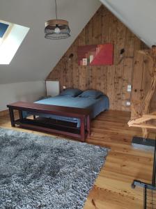 una camera con letto e parete in legno di La Petite Roupie a Bretteville
