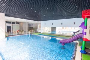 a large swimming pool with a slide in a building at Vung tau seaview apartment 2 - Nhavungtauorg - Son Thinh2 apartment - Oasky lounge in Vung Tau