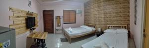 a bedroom with two beds and a television in it at DJCI Apartelle with own bath & kitchen 101-211 in Cabanatuan