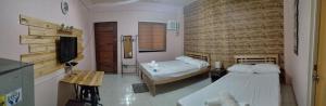 a bedroom with two beds and a television in it at DJCI Apartelle Walk to Robinson & NE Pacific Mall 3 Min to SM Cabanatuan in Cabanatuan