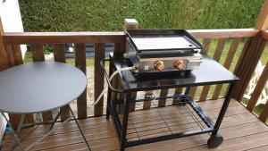 a grill sitting on a cart on a deck at Camping Les charmette les maths la palmyre in Les Mathes