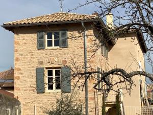 an old stone building with green shutters and a window at Pivoines in Saint-Julien +21 photos