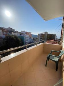 a chair on a balcony with a view of a city at 88 Apartment Himare in Himare