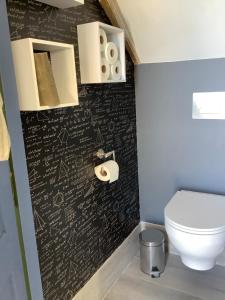 a bathroom with a black wall with writing on it at Pivoines in Saint-Julien
