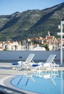 - un groupe de chaises et une piscine sur le toit dans l'établissement Marko Polo Hotel by Aminess, à Korčula