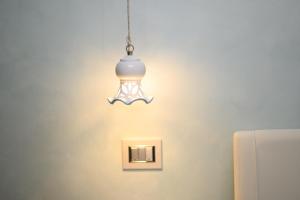 a light fixture hanging from a wall with a lightswitch at RosAmar in Bari