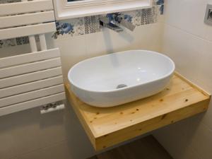 a white sink on a wooden table in a bathroom at RosAmar in Bari