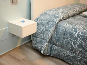 a bed with a night stand next to a side table at RosAmar in Bari
