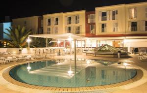 uma piscina em frente a um edifício à noite em Marko Polo Hotel by Aminess em Korčula