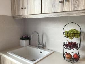 a kitchen counter with a sink and a basket of fruit at Aria Lito Mansion in Fira